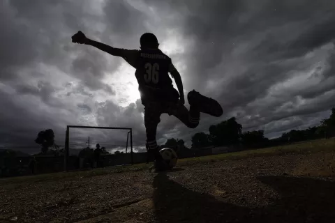 Un niño de la escuela Misericordia F.C., patea un balón de fútbol hacia la portería durante su práctica en el campo de entrenamiento, en el barrio Canchunchú, Carúpano, estado Sucre, Venezuela, el viernes 3 de noviembre de 2023.
