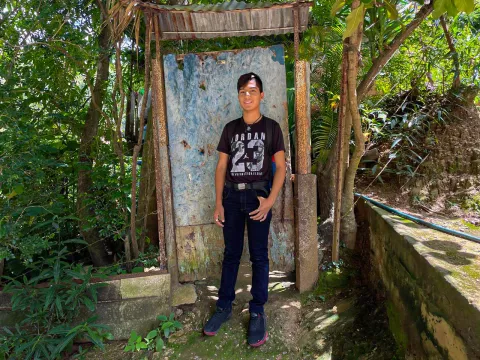 Luis González (15 years old) smiles for the camera standing at the door of his home in Las Tejerías, Aragua state, Venezuela, on 13 July 2023.