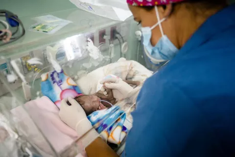 Una enfermera proporciona oxígeno y medicamentos a un bebé recién nacido dentro de una incubadora en un centro de salud apoyado por UNICEF en Caracas, Venezuela.