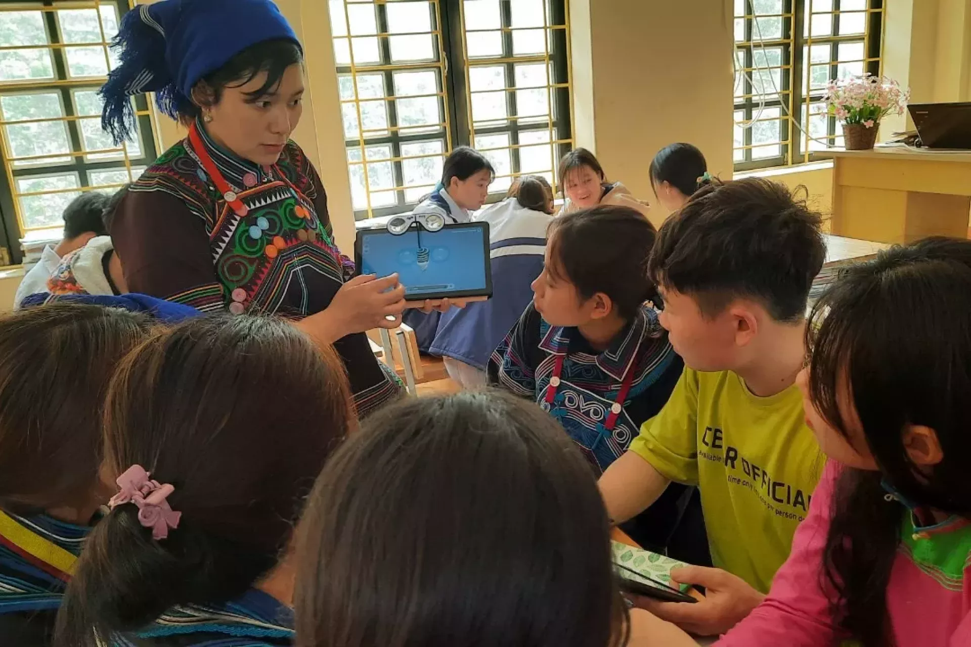 An ethnic minority teacher introduces her lesson to students using a tablet. Digital divide is still to be narrowed for students living in remote areas.