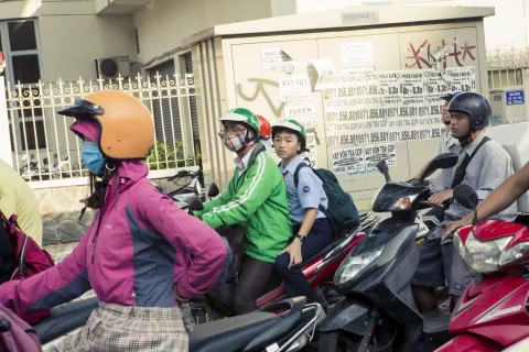 Tài xế công nghệ Grab và một học sinh nam đi xe máy trên đường