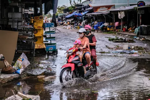 A family tries to get over a flooded road caused by Typhoon Noru on September 28, 2022 in Tam Ky City, Quang Nam Province, Viet Nam.