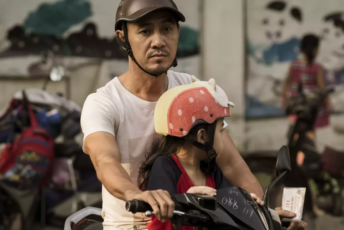 Bố chở con gái đi học bằng xe máy