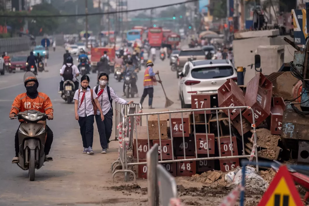 Air pollution - People move through a dusty construction area on Kim Dong Street, Hai Ba Trung District, Ha Noi.