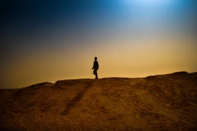 A boy walks on the sand bank surrounding M'Bera refugee camp. 