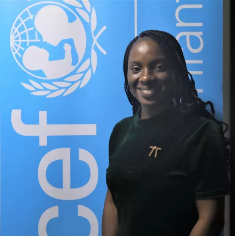 Portrait of a young woman smiling, with a UNICEF backdrop