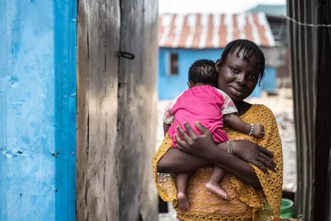 A mother holding her baby in an urban slum in Nigeria