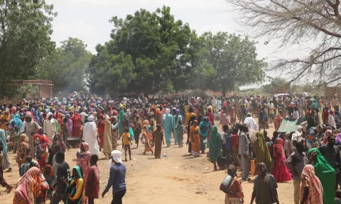 Hundreds of refugees including women and children standing outside at a border town in Chad