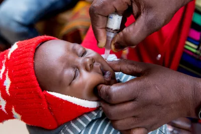 A nurse administers an oral poliovirus vaccine (OPV) to a baby