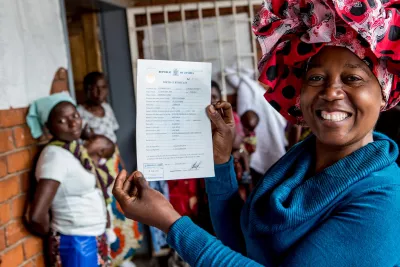 A mother holds her daughter's birth certificate after registering her birth