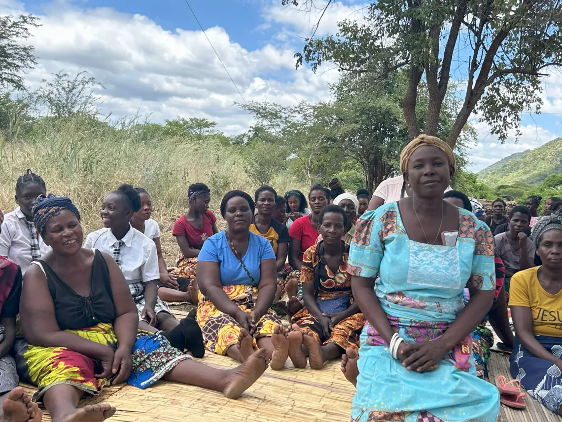 Induna Regina, displaying her deep care, poses for a photo alongside the remarkable women in her village.
