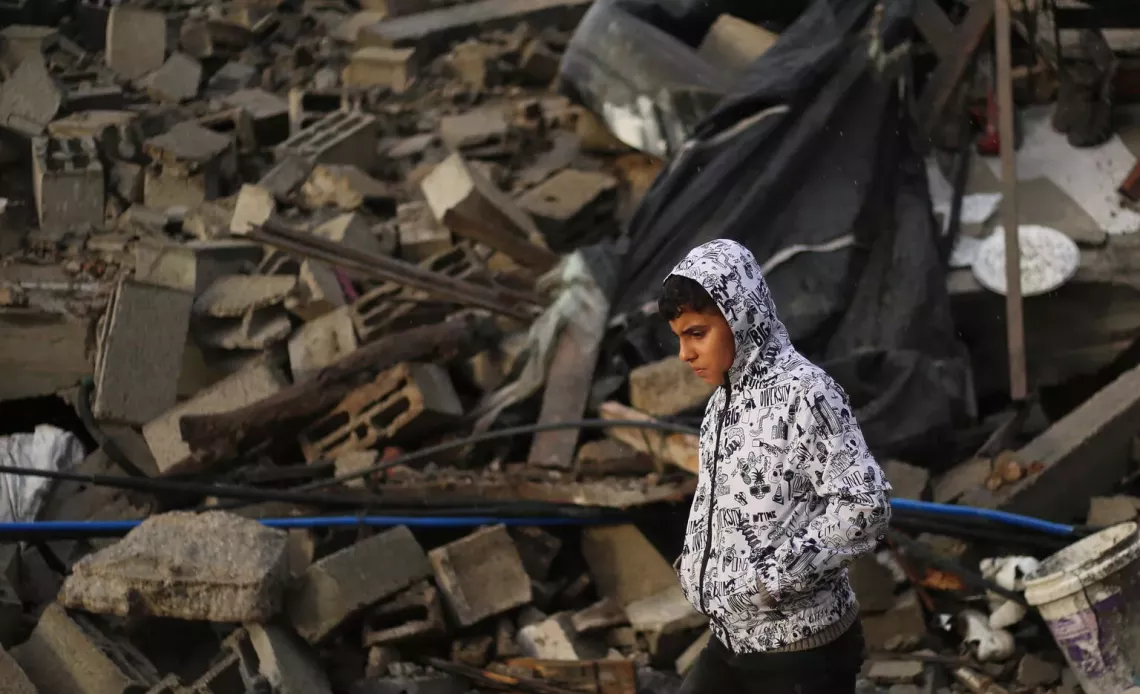 Gaza Strip. A boy walks past a destroyed building in the city of Rafah, the Gaza Strip.