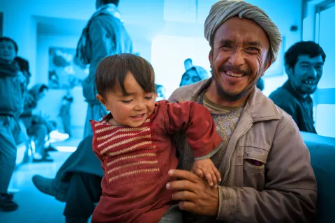 On 27 November 2022, a father tickles his young son at a healthcare facility in Bamyan Province, central Afghanistan.