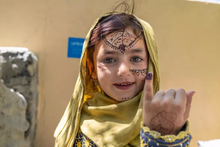 In Spera, a girl shows the ink mark on her finger she received after being vaccinated against polio. 
