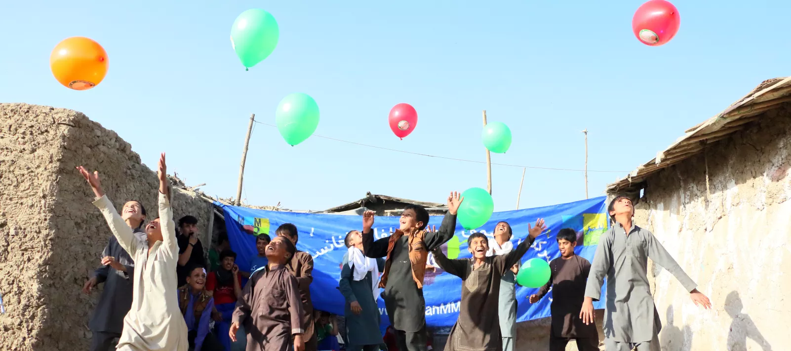 Children jump as they release balloons into the sky. Kabul, Afghanistan