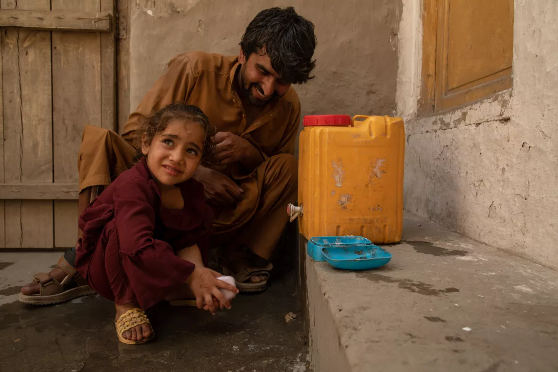 Kamaluddin, 23, helps his 6-year-old niece, Asra, wash her hands at their home in Qarghaye District, Laghman Province, Afghanistan.