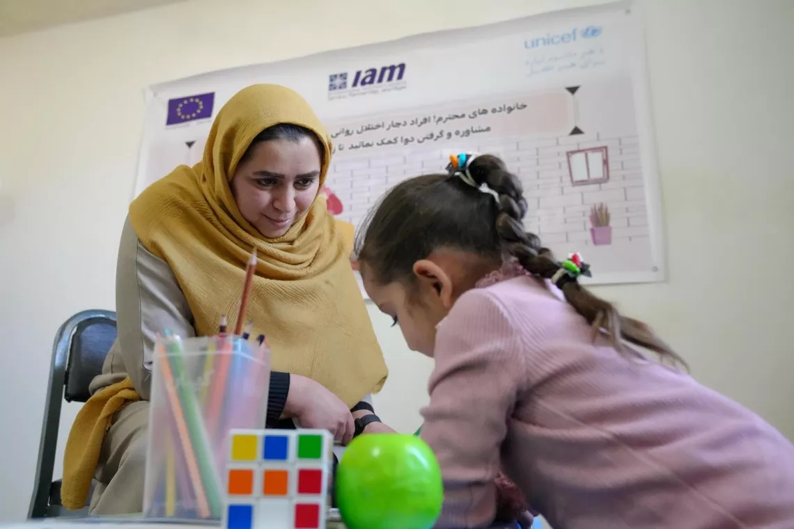 Dr. Hamedi plays with a little girl at the UNICEF supported child and adolescent mental health clinic where she works in Herat, Afghanistan..