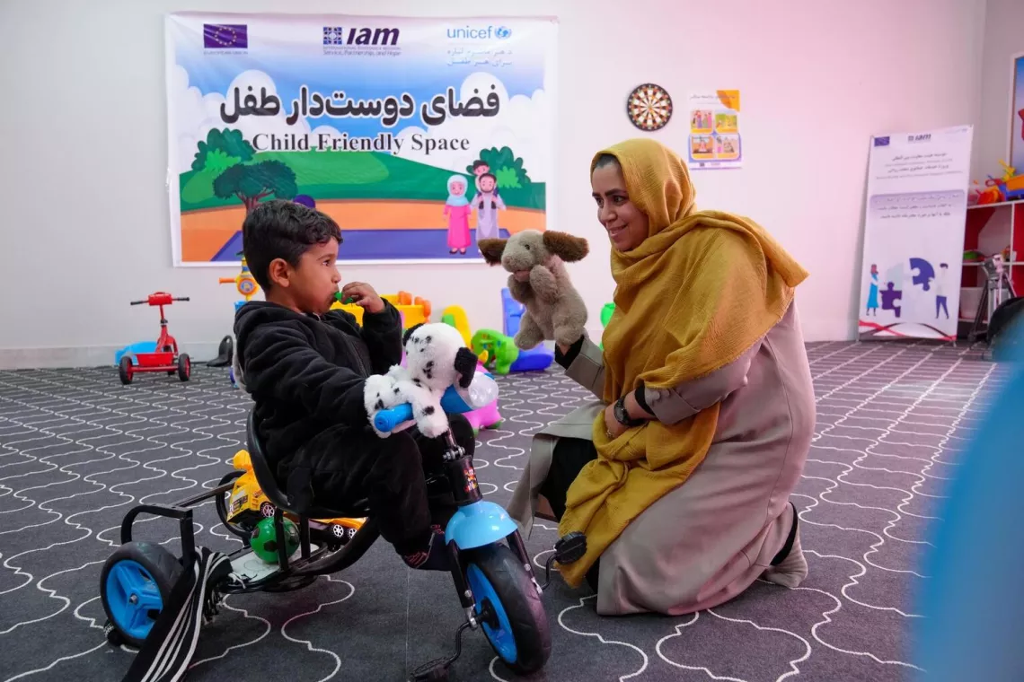 At the UNICEF supported child and adolescent mental health facility in Herat, Afghanistan, Dr. Tayeba Hamedi plays with a child inside the child friendly space.