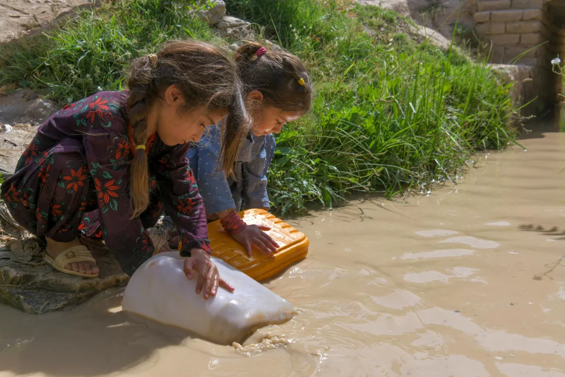 On 14th June 2023, Sahar and Hasina both 6 years-old with jerry can collect dirty water from a stream in the community for their families in Chamtal District in Balkh Province, Afghanistan.