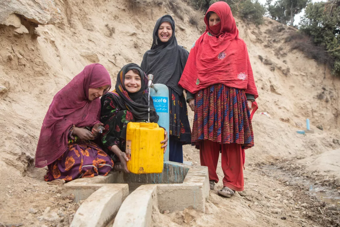 On 29 November 2023, Adila, centre, fills her jerry can from a new water tap in Payok Abad village in Nuristan province's Kantiwa Valley in Afghanistan, where she never had clean and safe water before.