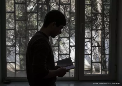 A 17-year old boy reading poems by a window in a room of "Noubarashen" penitentiary institution for adolescents.
