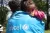 A bay girl is resting her head on UNICEF employee's shoulder