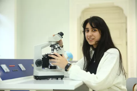 a young person with a microscope 