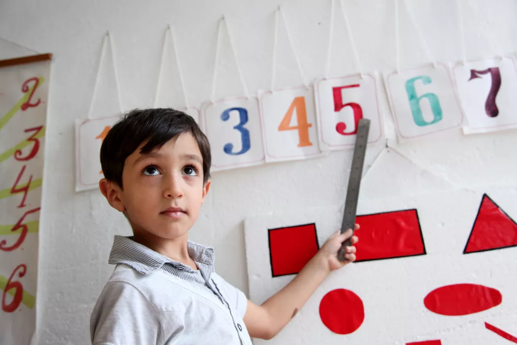 A boy learns how to read numbers.
