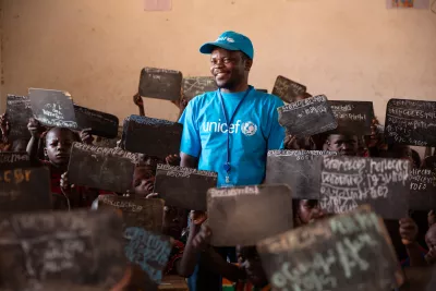 Nestor Yamenenji in a classroom with students holding their chalkboards up in the town of Paoua, in Central African Republic