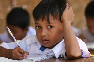 A boy looks up from writing in Seyegan Elementary School in Pundong Village, Indonesia