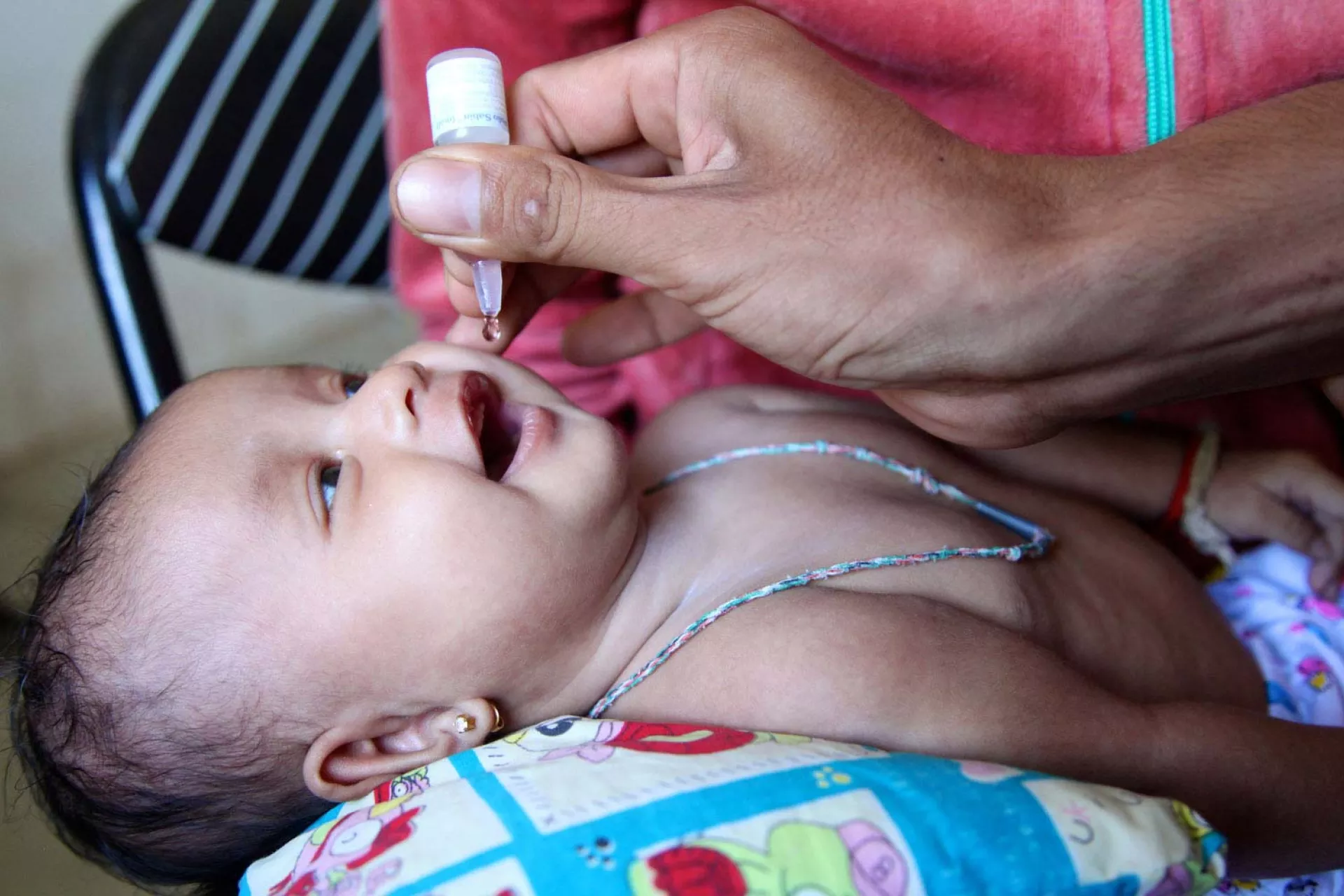 A child is administered an oral vaccine during a routine immunization session at the health centre in the village of Preak Krabao, Kang Meas District, Cambodia