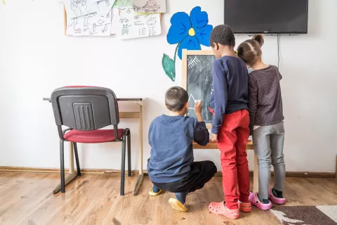 Children draw on a board at the Magura Residential Center in Codlea in Brasov, Romania
