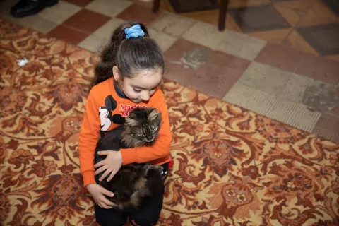 Five-year-old Nutsa plays with her cat Tsknapo in her family house.