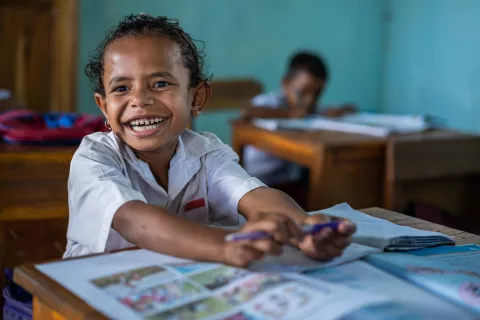 A student smiles in her classroom