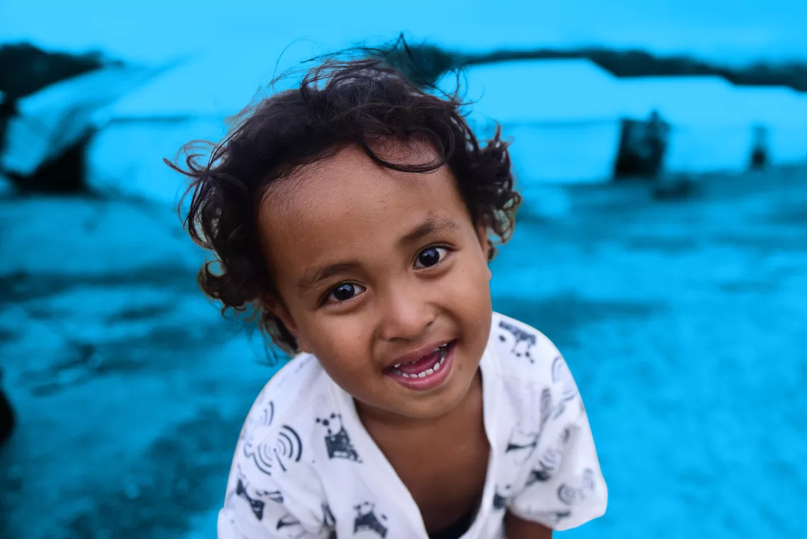 A child smiles in front of temporary housing for evacuees of the 28 September earthquake and tsunami.