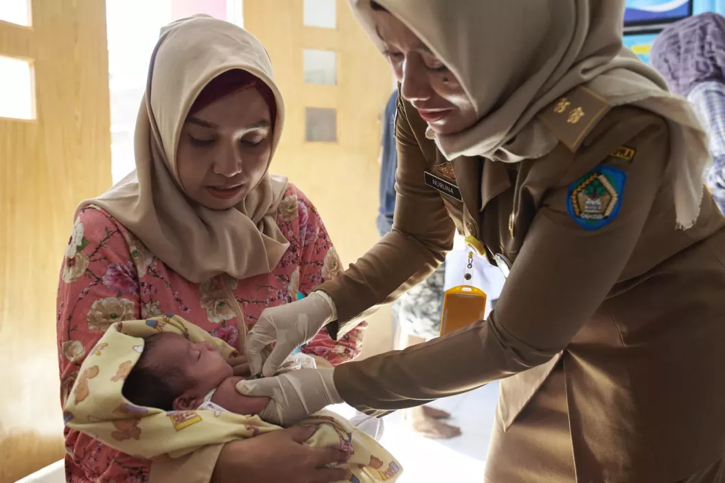 A health worker immunizes an infant 