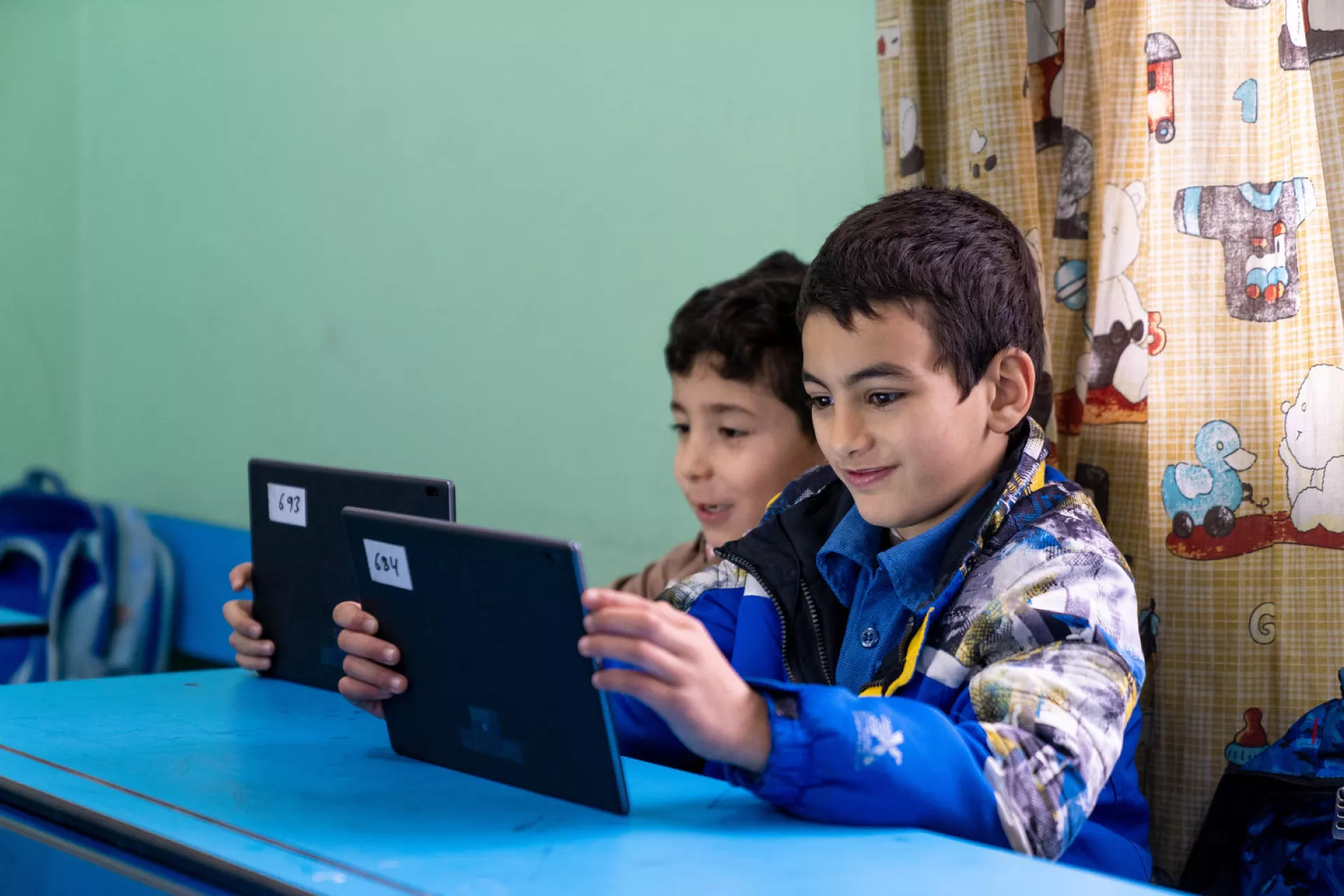 Two young boys at school learning from an IPAD 