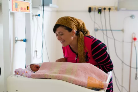 The woman looking at her newborn child at the hospital
