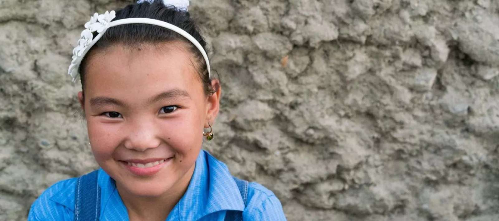 Молодая девочка в Кыргызстане смотрит в камеру
