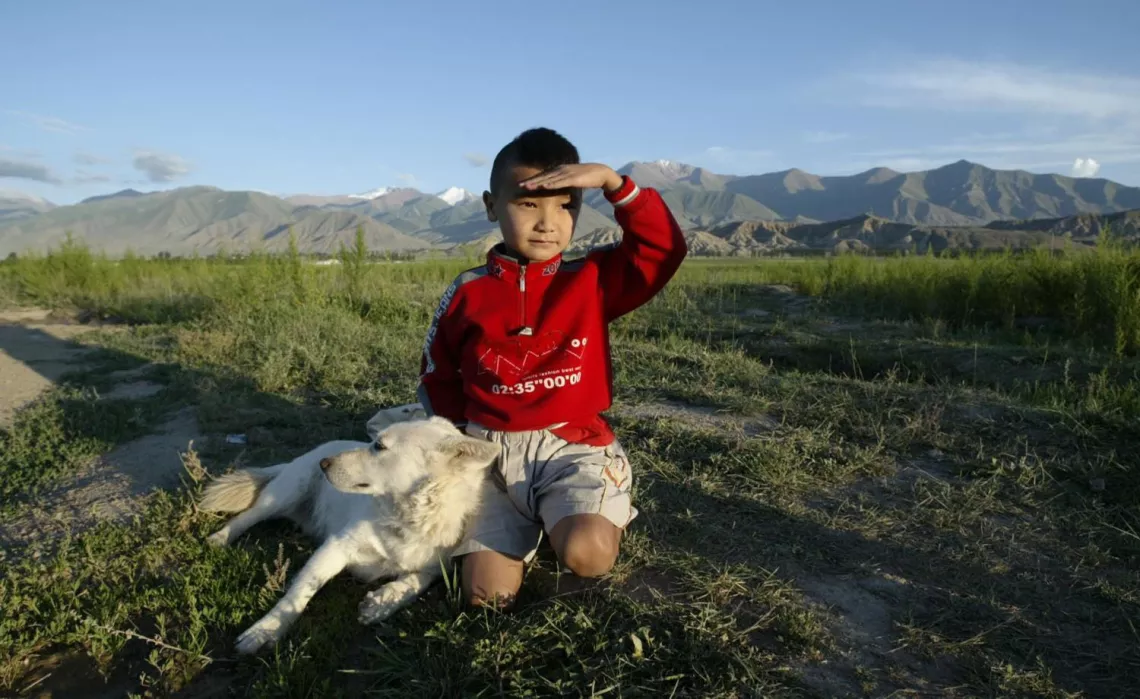 Boy with dog on the background of mountains