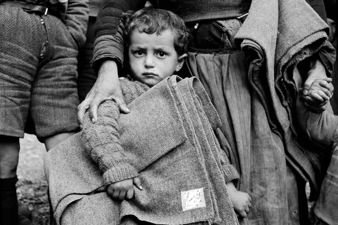 Мальчик в Греции держит одеяло от ЮНИСЕФ