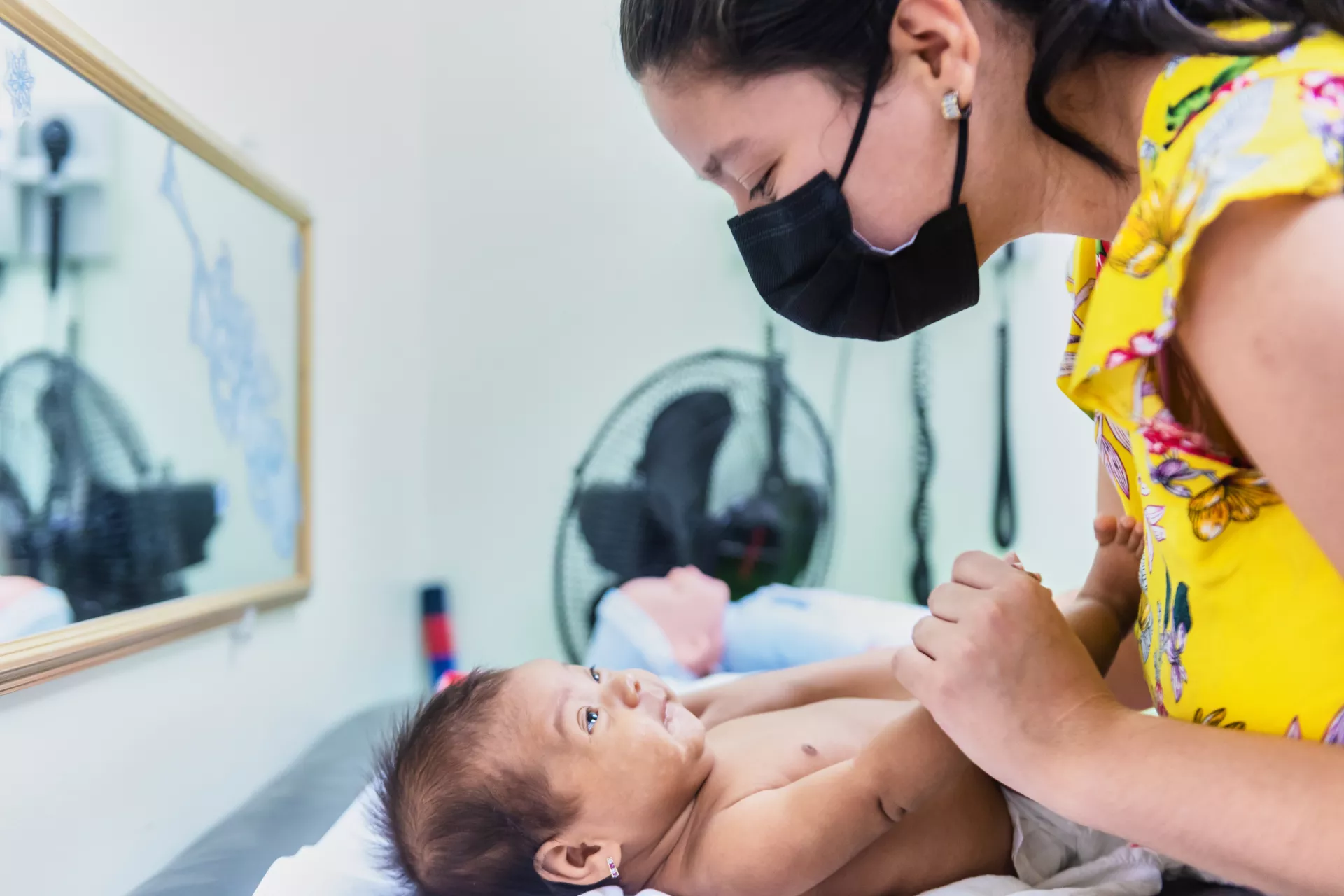 Una madre interactúa con su hija durante una visita al pediatra.