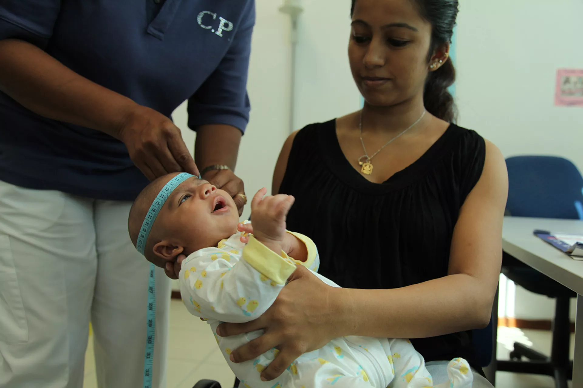 Un trabajador de la salud mide la circunferencia de la cabeza de un bebé durante un examen de rutina, en una clínica de maternidad maternoinfantil en Philipsburg, Sint Maarten. 