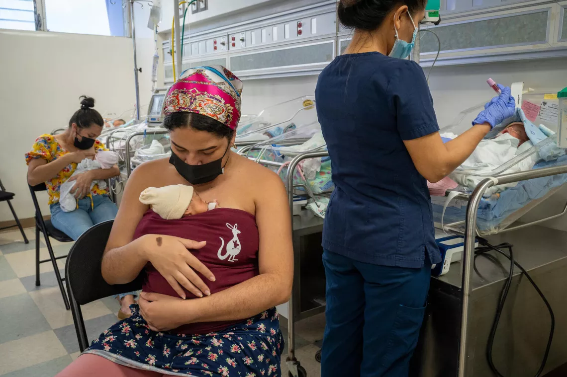 Niña recién nacida apoyada en el pecho de su madre, plan canguro, en un hospital.