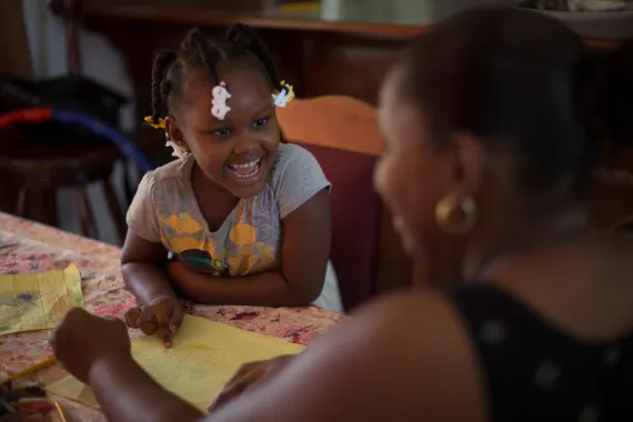 On 20 August 2016 in Belize, 4-year old Zyrah Neal laughs as she and her mother, Sherlette Neal, draw at home at their dining room table, in Belmopan, the capital. Zyrah lives in a middle-class neighbourhood with her mother (who is a government employee), her sister and two brothers.