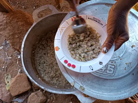 Vanonteza en train de distribuer les repas dans les bols alimentaires fournis par l’UNICEF.  