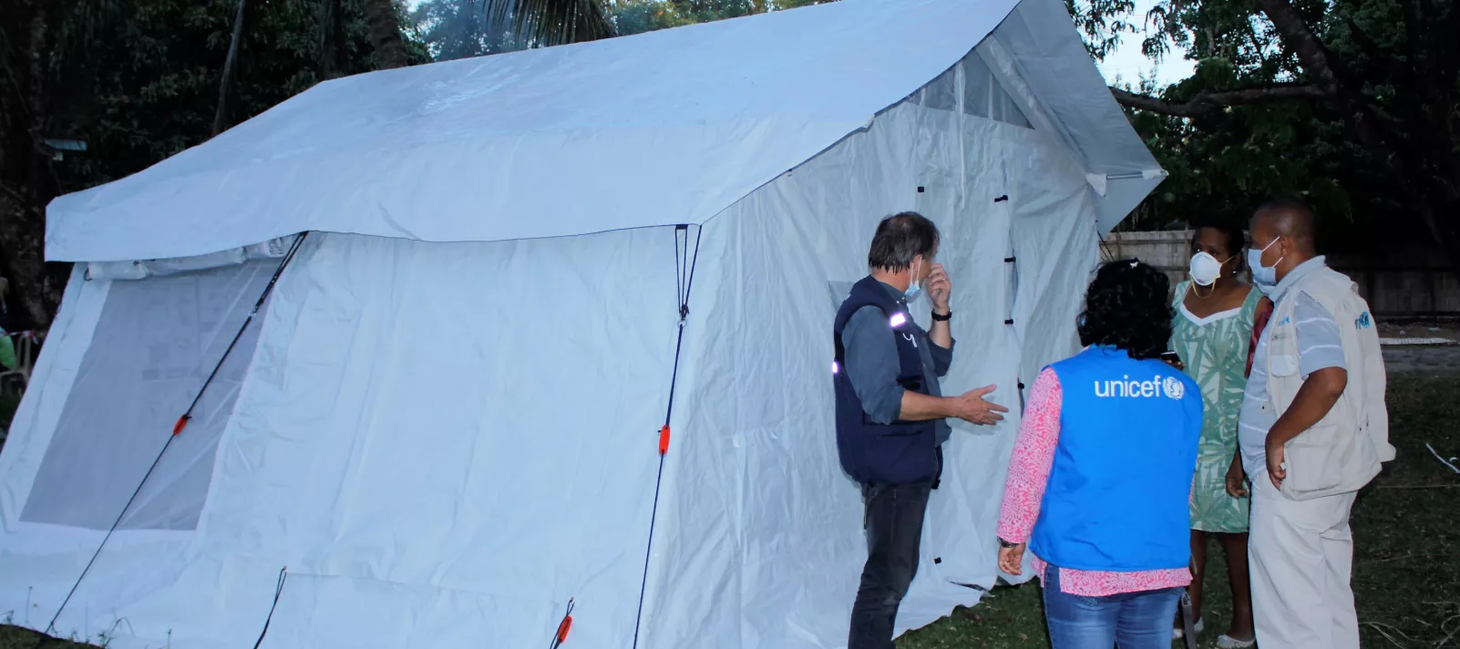 Des personnels de l'UNICEF discutent pres d'une tente d'urgence