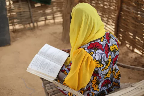 Hawa (nom d'emprunt) étudiante de 17 ans au lycée de Bafoulabé est en train de lire un livre de grammaire dans la cour de son logement.