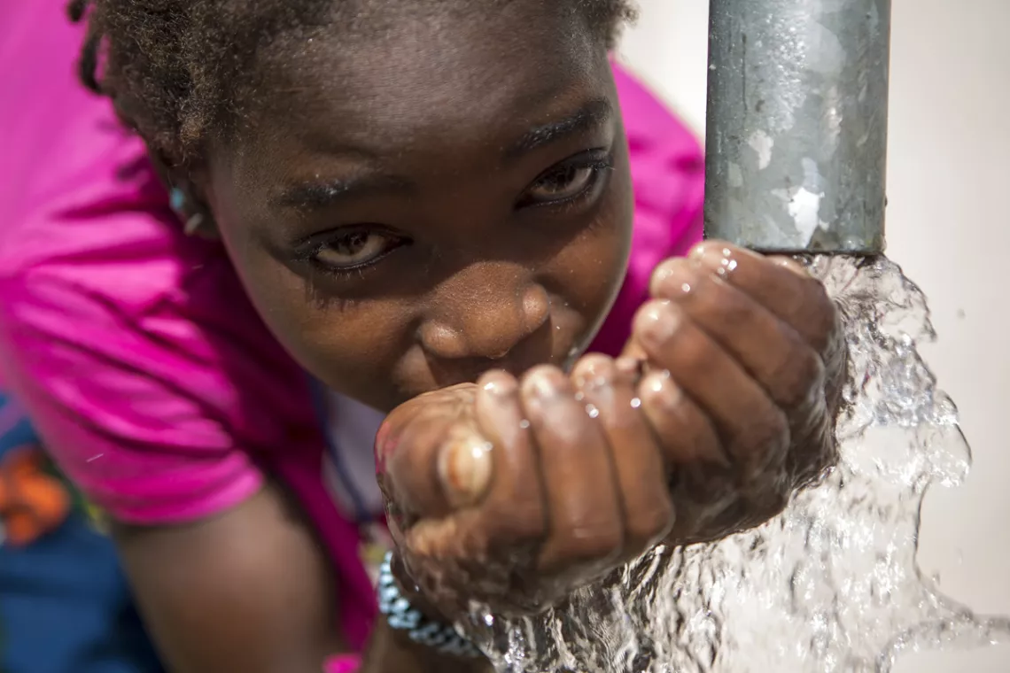 une fille entrain de boire du point d'eau de son école 