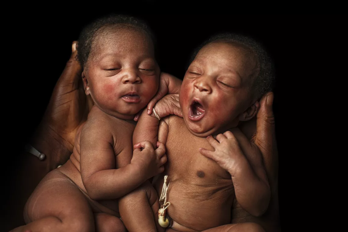 On 7 March 2018 in Mali, 1-day-old twins are cradled by their mother, Fatoumata Traore (hands visible), at the Reference Health Centre in Bougouni.